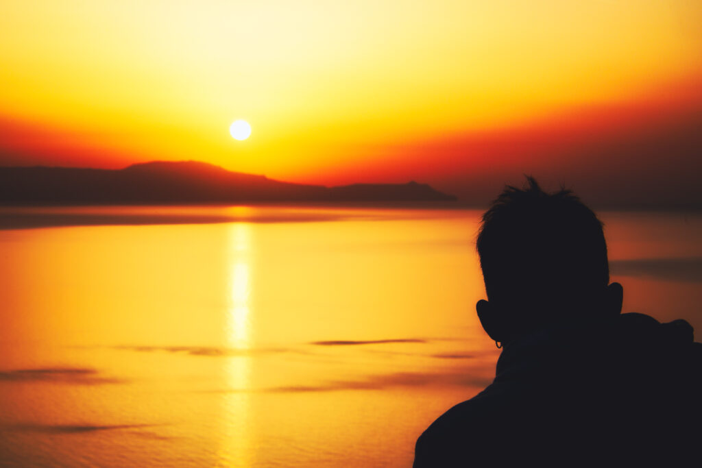 Kopf eines Mannes als Silhouette vor Kretas Küste bei Chania zum Sonnenuntergang